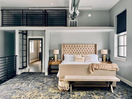 Image de la chambre d'hôtel montrant un lit et un espace loft